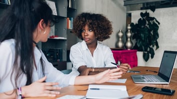 Two women discussing an assessment